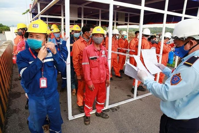  Công tác kiểm soát an ninh tại cổng A1, A2 NMLD Dung Quất là vô cùng quan trọng. Bởi đây là cửa ra vào chính của nhân sự nhà thầu. BSR đã lên phương án, phối hợp với Công an tỉnh, Công ty PVS miền Trung kiểm soát an ninh, vật tư cá nhân của các nhân sự tham gia BDTT. Trong hình: Công nhân nhà thầu được tập trung kiểm soát thẻ ra vào, giấy phép làm việc 