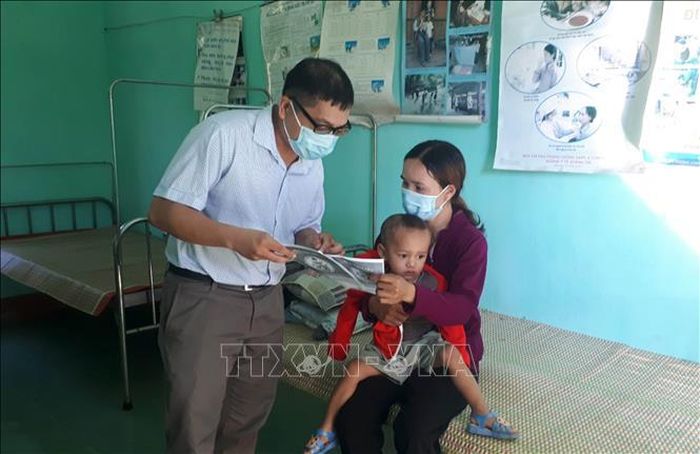 Cán bộ y tế địa phương của tỉnh Quảng Trị phát tờ rơi tuyên truyền về bệnh bạch hầu để người dân phòng tránh. Ảnh: Hồ Cầu/TTXVN
