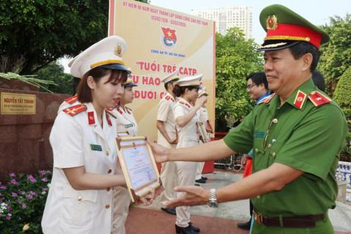 Thiếu tướng Trần Đức Tài, Phó giám đốc Công an TPHCM trao bằng tuyên dương CBCS hoàn thành xuất sắc nhiệm vụ. Ảnh: MAI ANH