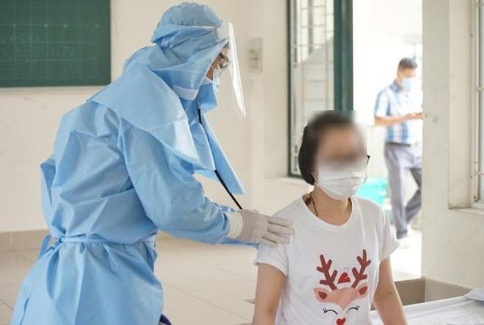 Nhân viên y tế tại Khu cách ly trung tâm quận 2 chăm sóc sức khỏe cho người bị cách ly.