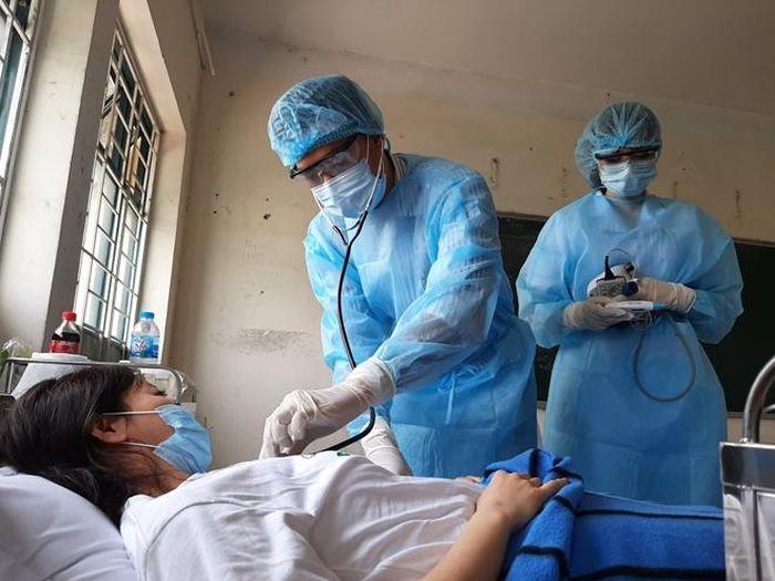Nhân viên y tế tại Khu cách ly trung tâm quận 2 chăm sóc sức khỏe cho người bị cách ly