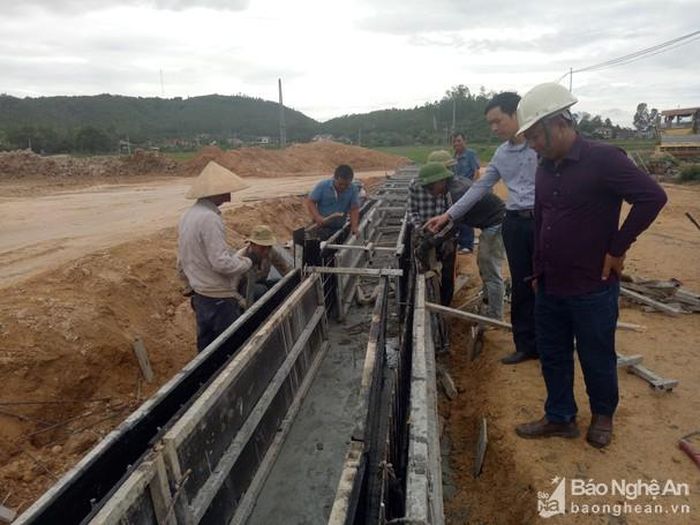Công nhân thi công hệ thống mương tiêu thoát nước ở khu tái định cư xã Nghi Phương. Ảnh: Văn Trường