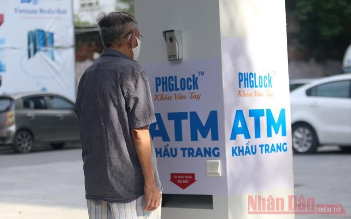 Thao tác “rút” khẩu trang bằng cách đứng trước máy quay nhận diện thông minh gắn kèm thiết bị ATM.