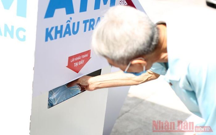 Sau đó nhận khẩu trang y tế từ cây ATM.