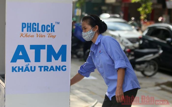 Người dân nhận khẩu trang y tế từ "cây ATM khẩu trang", sáng 25-8 tại Hà Nội.