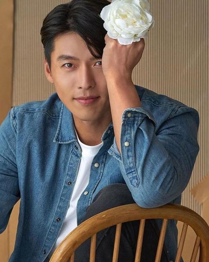 Tóc mái bổ đôi, áo thun trắng và áo jean khoác ngoài là cách Hyun Bin hóa thân thành một chàng sinh viên đôi mươi.