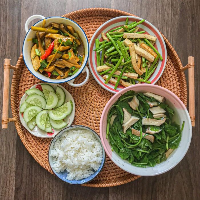 Mâm cơm bắt mắt này được chế biến từ 2 nguyên liệu chính là nấm đùi gà và nấm đông cô. Với món nấm rim nước dừa, bạn chú ý không nên thái quá nhỏ và tẩm ướp theo tỷ lệ 1/2 muỗng bột nghệ, 2 muỗng tương ớt, 3 muỗng nước tương, 1/2 muỗng ngũ vị hương, tiêu. Cuối cùng, bạn thêm 200 ml nước dừa rồi đun đến khi hỗn hợp cạn dần. Phần nấm thừa sẽ nấu cùng rau má, ăn kèm măng tây xào đậu hũ, dưa chuột, cơm trắng.