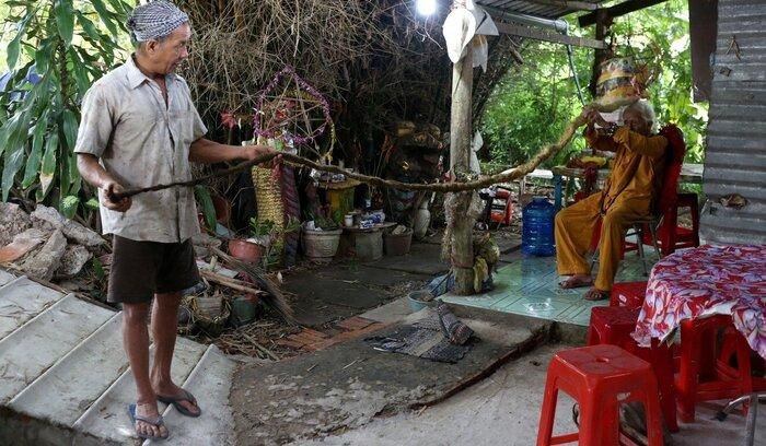 Ông Lượm giúp cha giữ mái tóc.