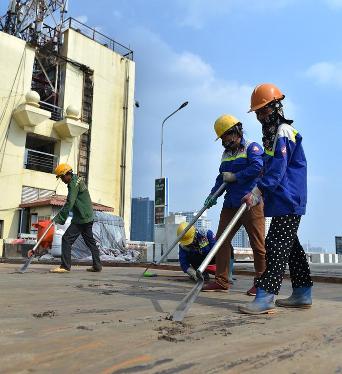 Công nhân bỏ lớp keo kết dính cũ nguyên thủy của cầu.