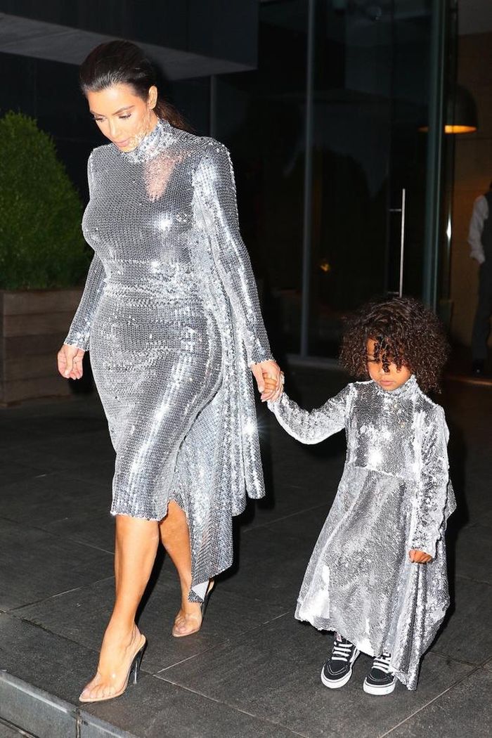 Kim Kardashian và con gái North West thu hút sự chú ý với bộ cánh màu bạc lấp lánh. Chọn trang phục nổi bật, vợ Kanye West tối giản về phụ kiện, không làm tóc hay make up cầu kỳ. Ảnh: The Sun.