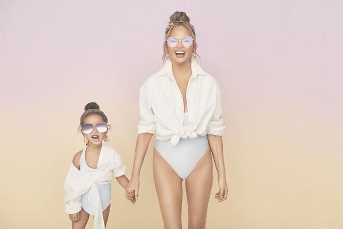 Người mẫu Chrissy Teigen và con gái diện đồ bơi một mảnh kèm áo sơ mi buộc ngang eo. Hai mẹ con kết hợp ăn ý khi có sự tương đồng về biểu cảm cùng tư thế tạo dáng. Ảnh: People.