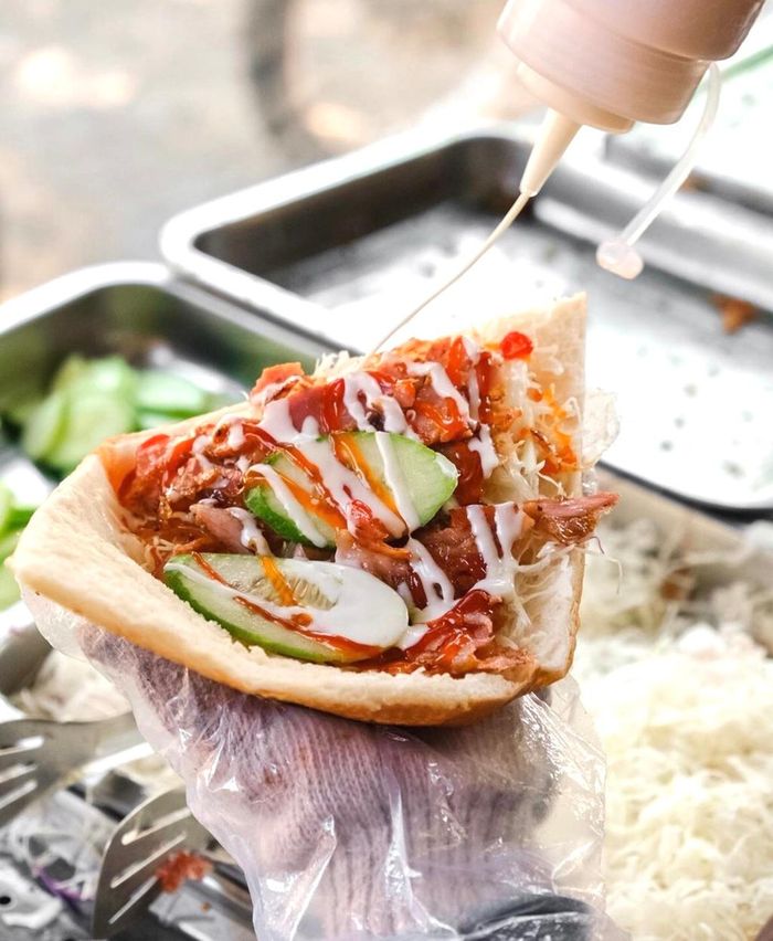 Tại TP.HCM, phần nhân kebab được thay thế với thịt lợn. Thịt được ướp đậm đà, nướng vừa đủ tạo độ mềm, phù hợp với khẩu vị người Việt. Lớp vỏ bánh giòn rụm cùng nước sốt hấp dẫn cũng góp phần khiến giới trẻ thích thú. Bạn có thể tìm thưởng thức hương vị này ở các xe bánh đường Nguyễn Thị Đặng, quận 12, hay đường số 17, quận Thủ Đức. Ảnh: Canquetsaigon.