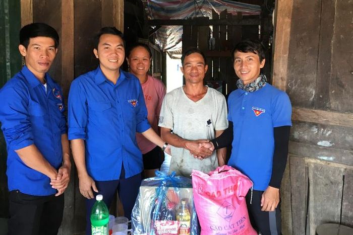 Anh Lại Hoàng Nhựt (ngoài cùng bên phải) trao quà cho người dân có hoàn cảnh khó khăn tại địa phương