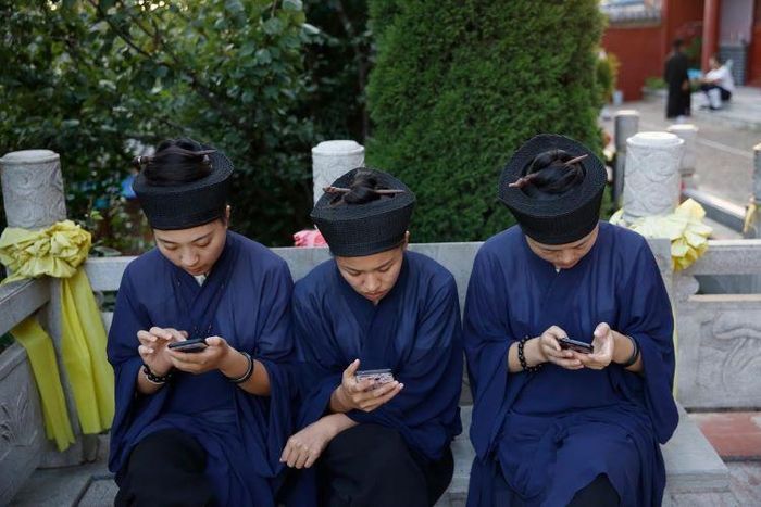 Các đạo sĩ nghỉ ngơi sau một buổi lễ tưởng niệm. Ảnh: Reuters