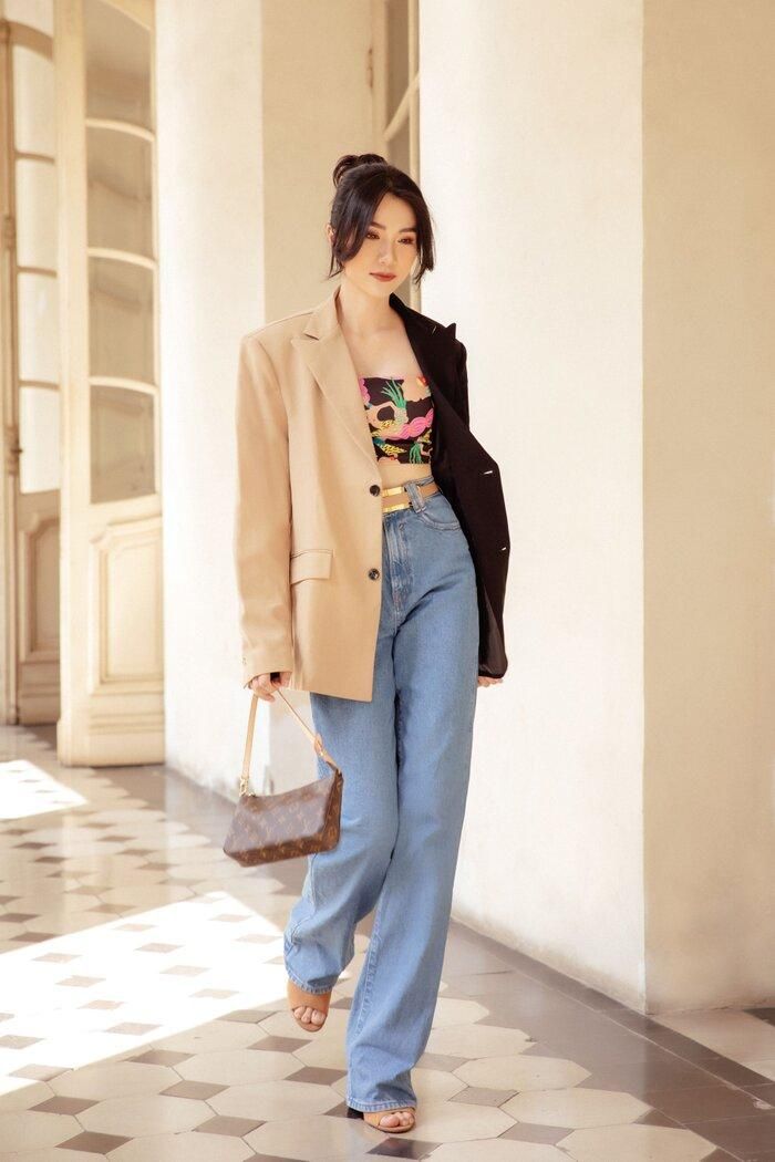Tiếp đó, MC Thảo Nhi chọn trang phục cô nàng công sở có phần cá tính hơn khi chọn blazer dáng rộng hai màu đen&amp; nâu bên trong là áo quây sặc sỡ đi kèm với jeans và túi xách mini