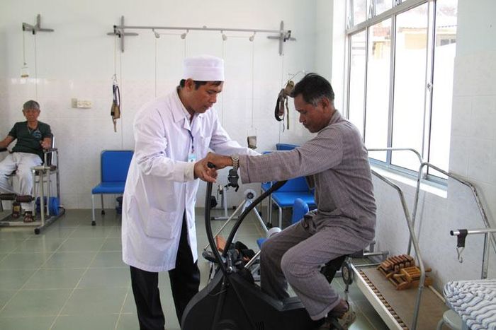 Bác sĩ K'Đỉu đang hướng dẫn bệnh nhân tập phục hồi chức năng chống tàn phế do di chứng của bệnh phong