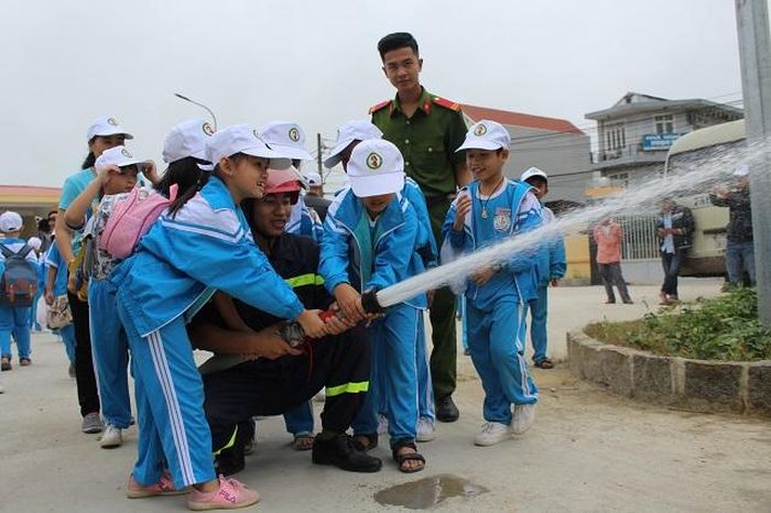 Các em thử sức với vòi chữa cháy. Ảnh minh họa