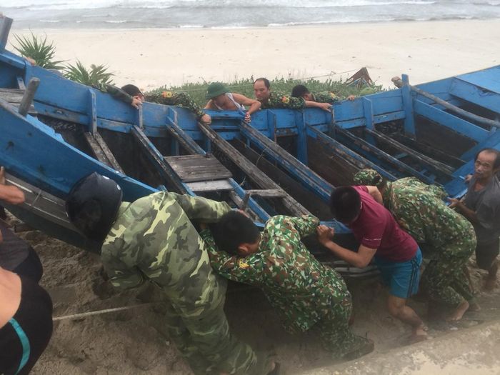 Cán bộ chiến sĩ Đồn BP 200 (Lệ Thủy - Quảng Bình) giúp ngư dân đưa tàu lên bờ tránh bão.