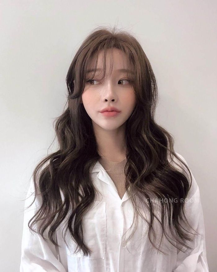 Để gương mặt trở nên bớt dài hơn, hãy thử tăng chiều rộng gương mặt bằng cách diện tóc mái thưa uốn dập sóng để gương mặt trông mềm mại. 
