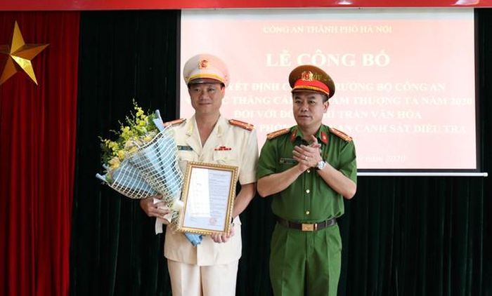 Đại tá Nguyễn Thanh Tùng - Phó Giám đốc CATP Hà Nội trao Quyết định thăng cấp bậc hàm của Bộ trưởng Bộ Công an và tặng hoa cho Thượng tá Trần Văn Hóa