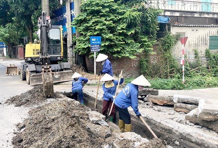 Công nhân tổ thoát nước làm nhiệm vụ khơi thông cống.