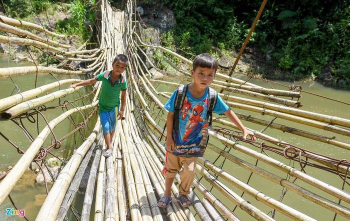  Học sinh đến trường trên chiếc cầu đơn sơ bằng những thân cây lồ ô ghép nối, rung lắc như chiếc võng bắc ngang suối Nước Mù. 