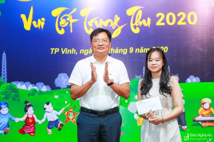 Đồng chí Ngô Đức Kiên - Phó Tổng Biên tập Báo Nghệ An trao thưởng cho cháu Trần Bảo Ngọc - đạt danh hiệu học sinh giỏi trường, thi đậu vào đại học. Ảnh: Đức Anh