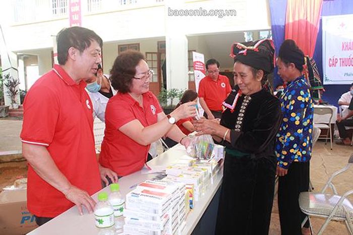Đại diện Hội Chữ thập đỏ tỉnh cấp phát thuốc cho người cao tuổi xã Phiêng Khoài.