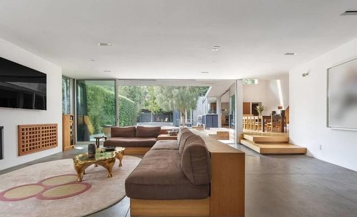  Phòng khách rộng rãi, thoáng đãng với điểm nhấn là bộ sofa sang trọng. Bức tường kính đem đến ánh sáng tự nhiên và cảnh sắc sân vườn. 