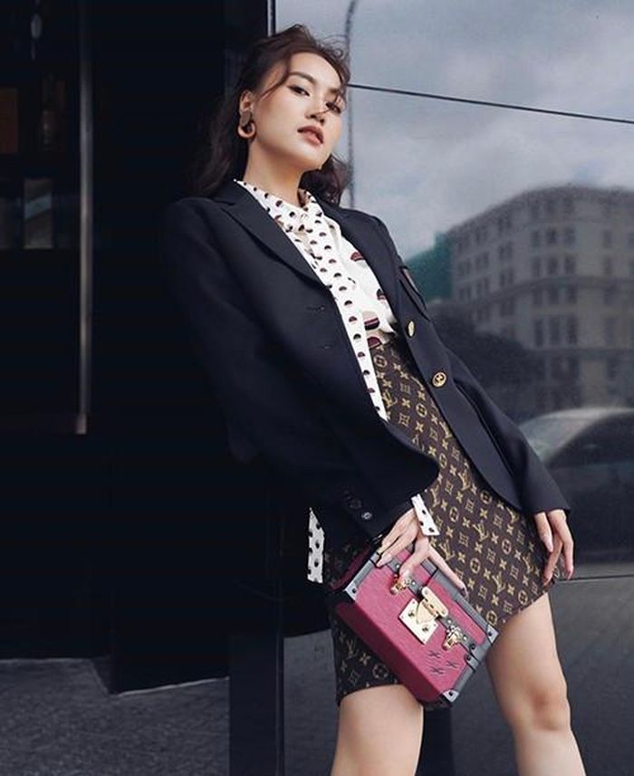 Ninh Dương Lan Ngọc hóa quý cô sang chảnh khi diện áo thắt nơ họa tiết chấm bi, chân váy nâu phối cùng áo vest đơn sắc và clutch xinh xắn.