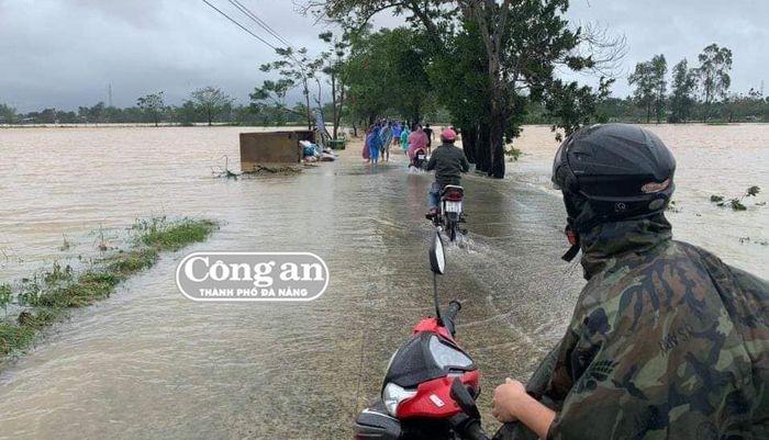 Người dân vẫn đi lại trên khu vực nước lớn băng qua đường.