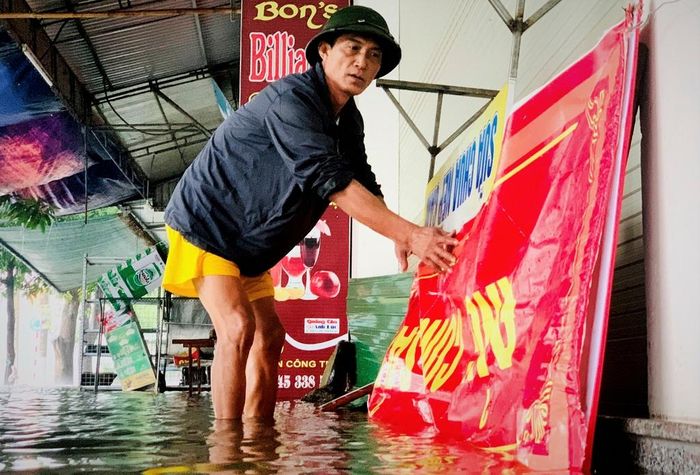  Người dân phường Thạch Quý (TP Hà Tĩnh) sử dụng mái tôn, biển quảng cáo chặn sóng nước đánh vào cửa. 