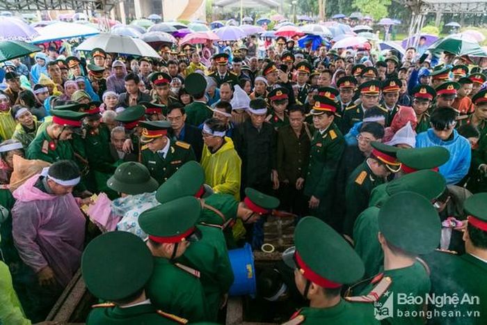 Hàng nghìn người đứng dưới mưa ở bên ngoài khu vực an táng để tiễn biệt các liệt sĩ. Ảnh: Đức Anh