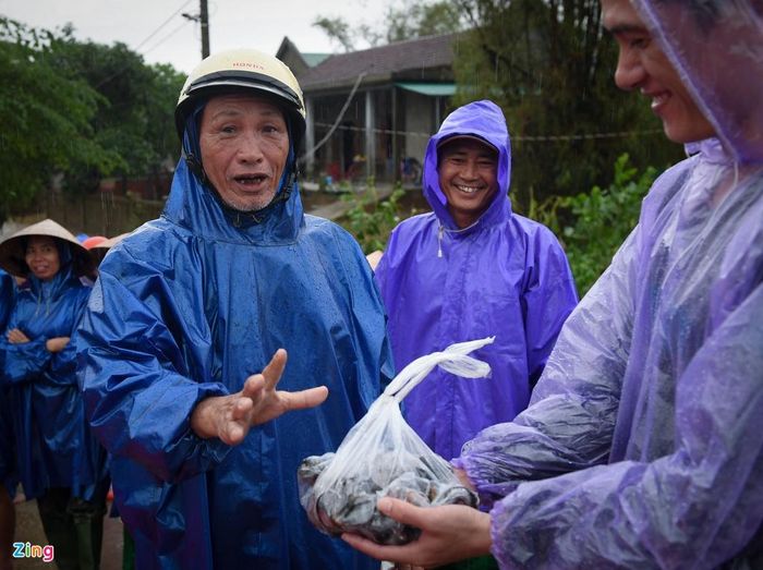  Ông Phạm Văn Phách, đại diện nhân dân xóm Cồn tặng túi ốc vừa bắt được cho đoàn từ thiện. Ông Phách cho biết người dân ở đây "6 tháng đi tay, 6 tháng đi chân", tức là 6 tháng dùng chân đi bộ, 6 tháng dùng tay chèo thuyền. Nhưng lũ năm nay lớn, lại lên nhanh nên nhiều người vẫn không kịp trở tay. 