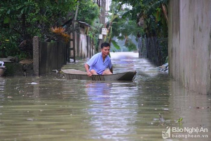 Người dân xóm 1, xã Châu Nhân phải di chuyển bằng thuyền do ngập sâu. Ảnh: Quang An