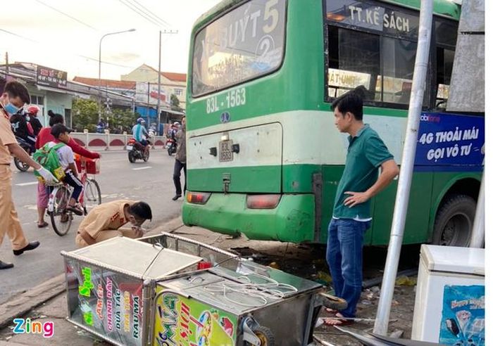 Chiếc xe buýt hất tung tủ nhôm của người bán cam ép trước khi lao vào nhà thuốc. Ảnh: Thanh Phú. 