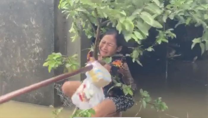 Chị Hiệu với tay lấy gói quà trong hai hàng nước mắt