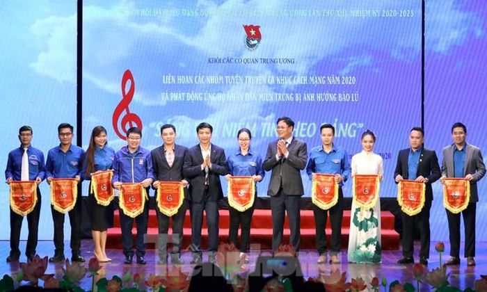 Ban Tổ chức tặng cờ lưu niệm biểu dương và ghi nhận 21 nhóm tuyên truyền ca khúc cách mạng tham dự Liên hoan. Trong ảnh ông Huỳnh Tấn Việt - Phó Bí thư Đảng ủy Khối các cơ quan Trung ương và anh Nguyễn Ngọc Lương - Bí thư T.Ư Đoàn, Chủ tịch Hội đồng Đội Trung ương trao cờ lưu niệm cho các nhóm.