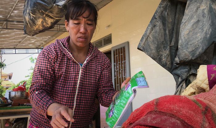  Chị Thúy nhặt nhạnh những gì còn sót lại sau lũ. Ảnh: Phạm Trường. 