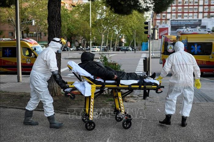 Nhân viên y tế chuyển bệnh nhân mắc COVID-19 tại Madrid, Tây Ban Nha. Ảnh: AFP/TTXVN