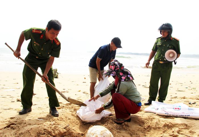 Lực lượng Công an xã Bình Hải hỗ trợ người dân chèn chống nhà của bằng bao cát