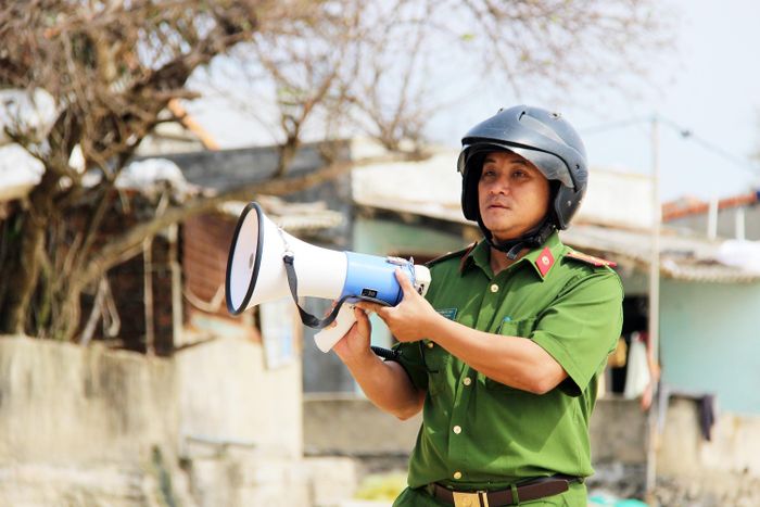 Trưởng Công an xã Bình Hải Nguyễn Đức Anh phát loa vận động bà con ven biển di dời khẩn cấp