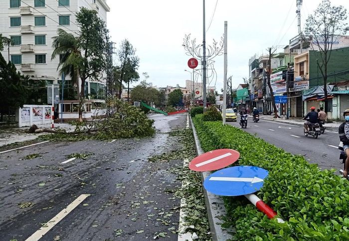 Bảng hiệu giao thông, cổng chào bằng sắt và cây cối ngã đổ tại đầu đường Lê Lợi và Quang Trung.