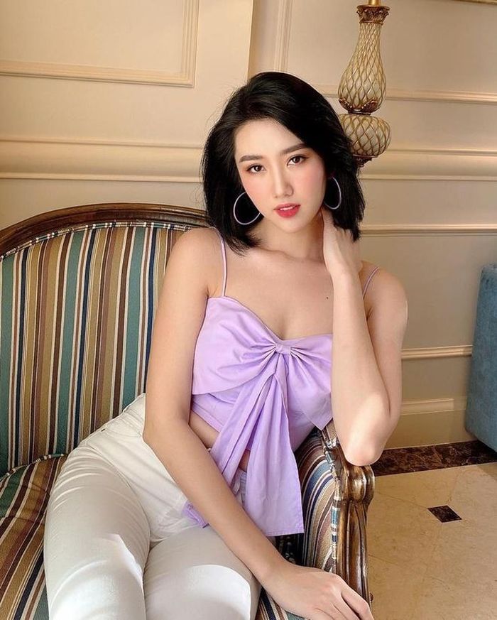 Thúy Ngân kết hợp áo 2 dây phối nơ thắt chính giữa với quần jeans trắng. Cô sử dụng phụ kiện hoa tai tròn, kết hợp trang điểm tông hồng nữ tính. Ảnh: @lehuynh.thuyngan.