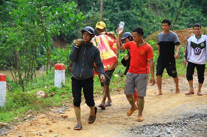 Những trai làng phải đi bộ hàng giờ đường rừng, vượt qua nhiều đoạn sạt lở nghiêm trọng mới đưa được người bị thương ra ngoài vì giao thông đang bị chia cắt.