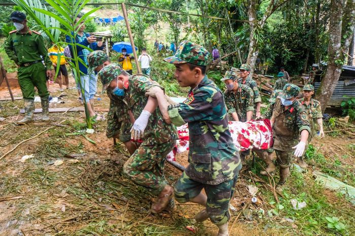 Lực lượng chức năng đang khiêng thi thể một nạn nhân vừa được tìm thấy.