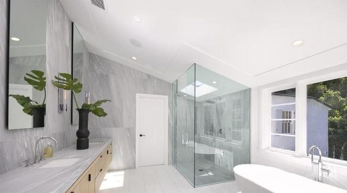  Phòng tắm chính rộng lớn, được ốp đá màu bạch kim và được trang bị đầy đủ tiện nghi cao cấp. 