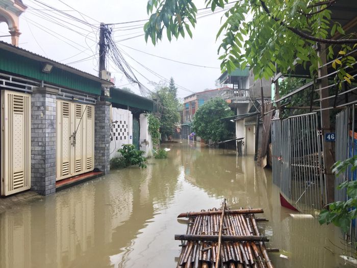 Người dân khối 9 phường Hồng Sơn, phía ngoài đê sông Vinh phải dùng bè nứa để đi lại. Ảnh: Nguyễn Hải