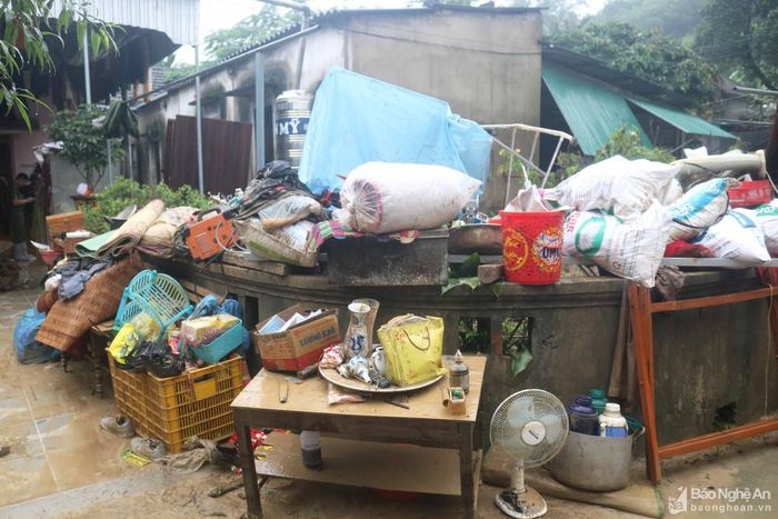 1 gia đình ở xóm Mỹ Hương chỉ có 2 ông bà già ở nhà, nước lũ vào không kê đặt được gì, tất cả tài sản đều ngâm trong nước. Sau lũ, người thân đến hỗ trợ khiêng ra sân, không ít tài sản đã bị hư hỏng. Ảnh: Huy Thư