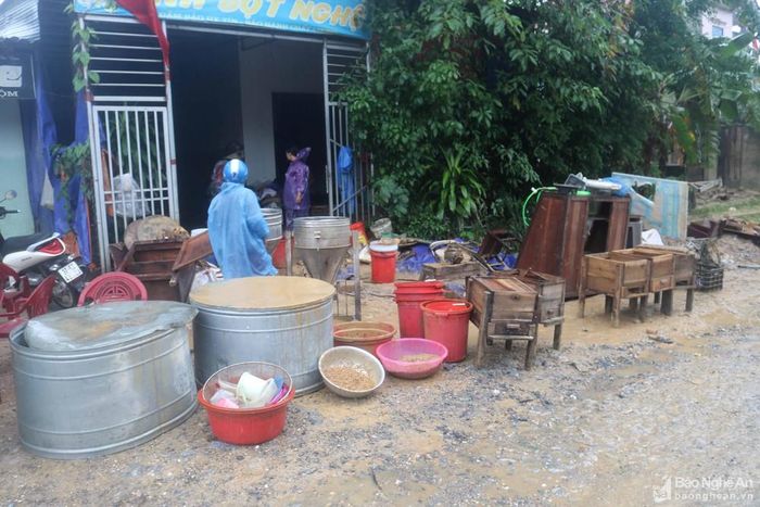 Dọc đường liên xã người dân khiêng nhiều đồ đạc còn bê bết bùn đất ra đường. Ảnh: Huy Thư